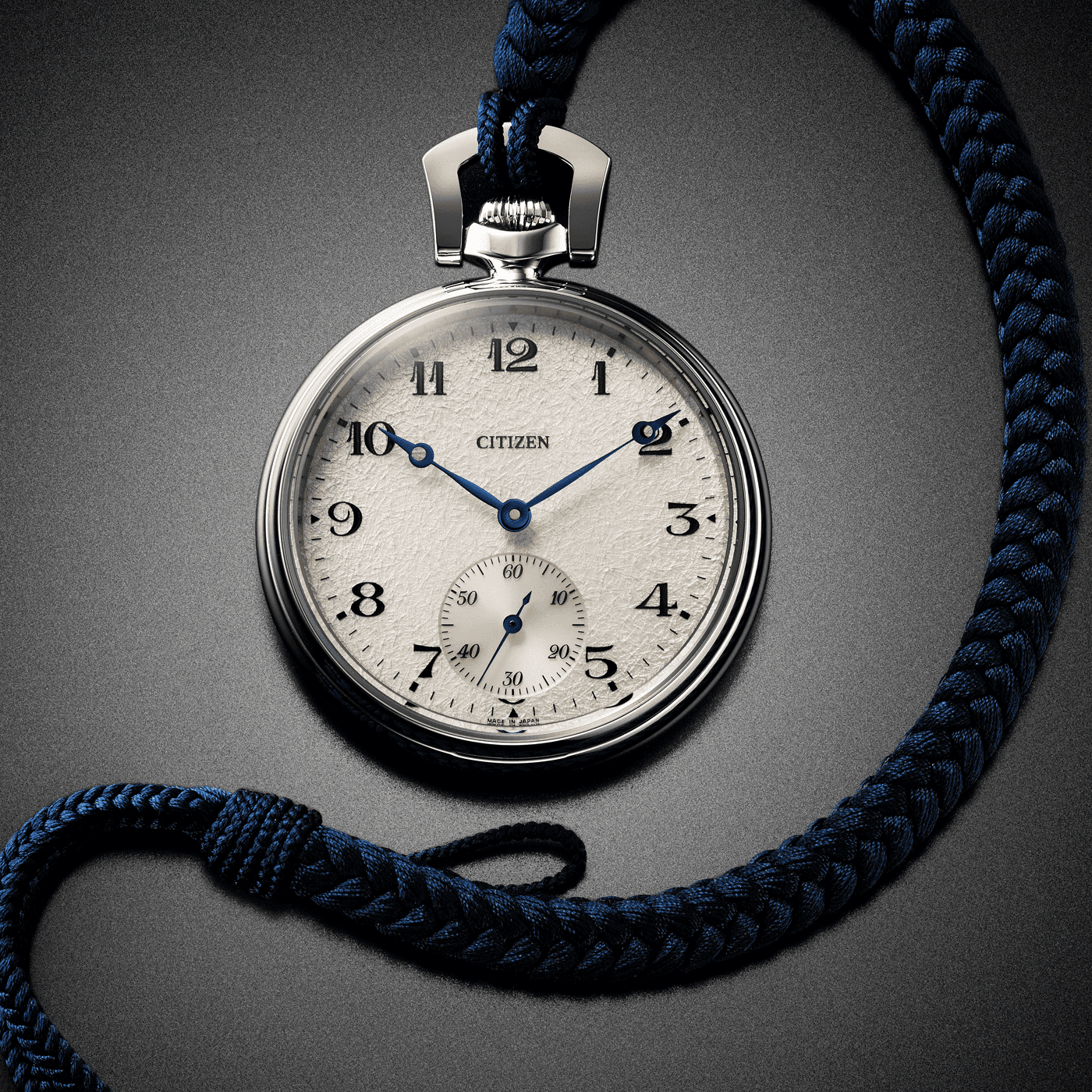 Close-up of a Citizen pocket watch with a blue braided cord on a gray background.