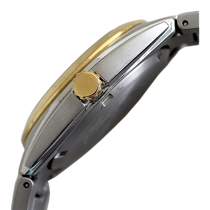 Close-up of a gold and silver watch with a crown and bracelet