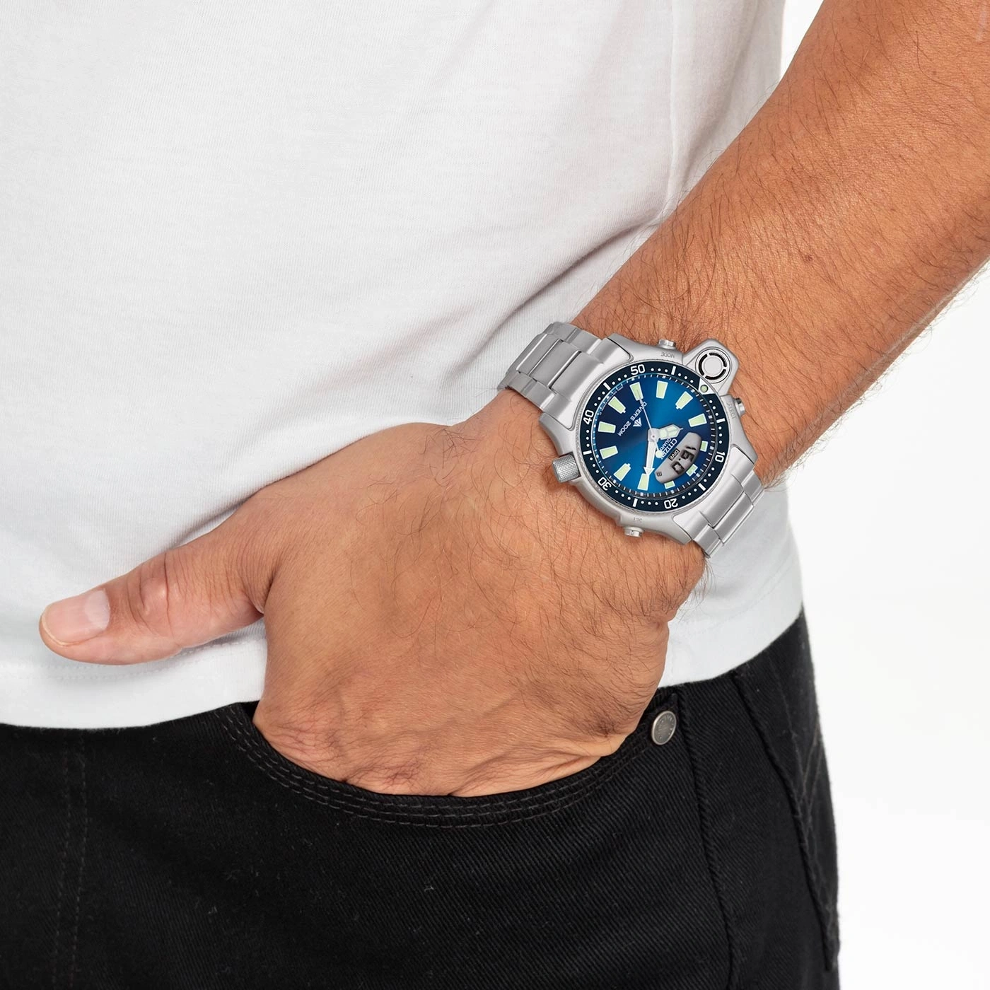 Man wearing a silver watch with a blue face, hand in pocket.