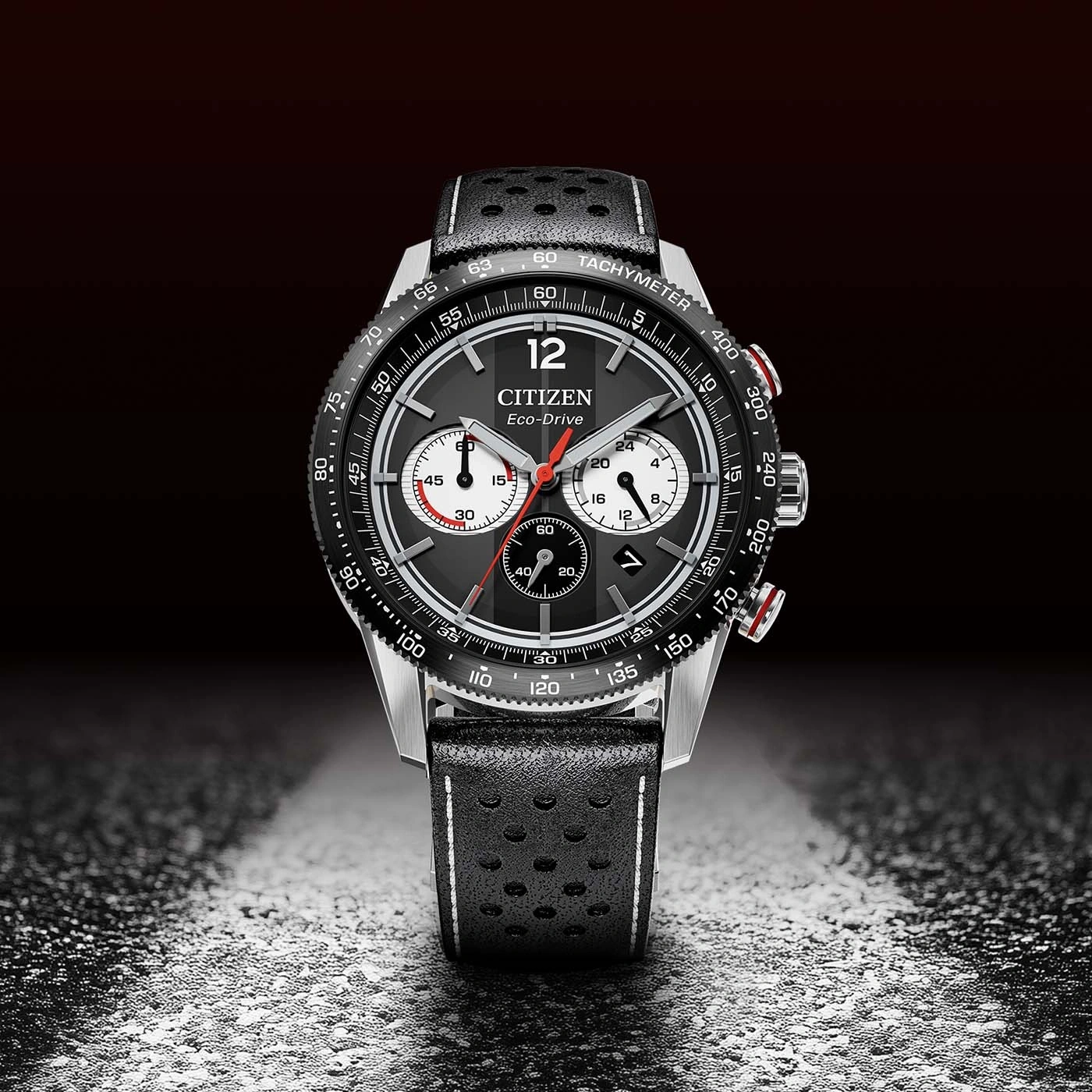 A black Citizen Eco-Drive chronograph watch with a perforated leather strap.