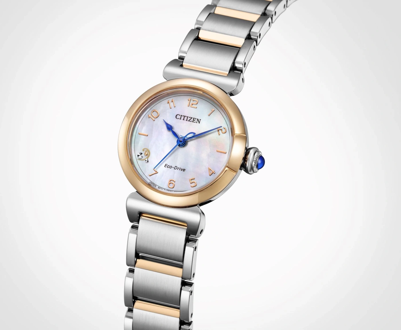 Citizen Eco-Drive watch with gold and silver accents, blue hands, and a mother-of-pearl face.