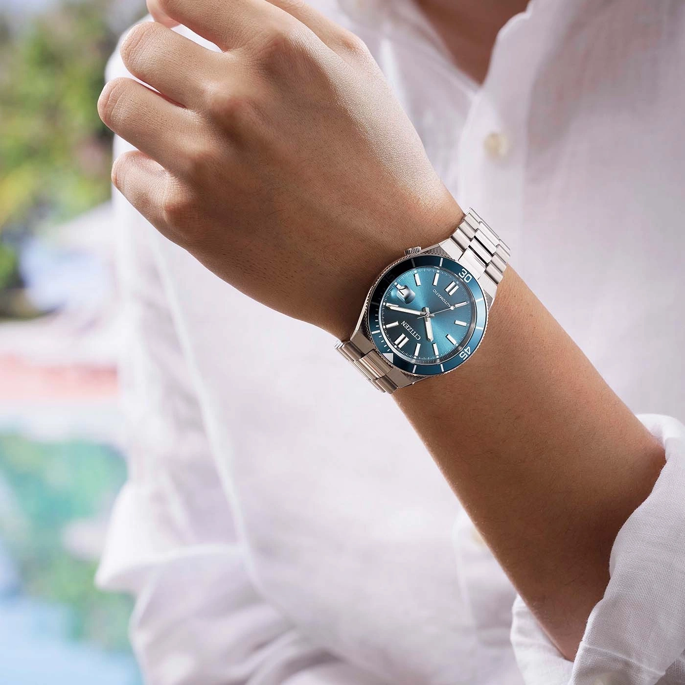 Man wearing a blue Citizen automatic watch on his wrist.