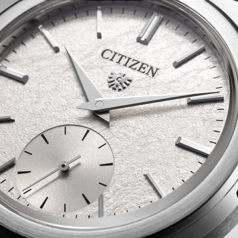 Close-up of a Citizen watch with a textured silver dial and hands.