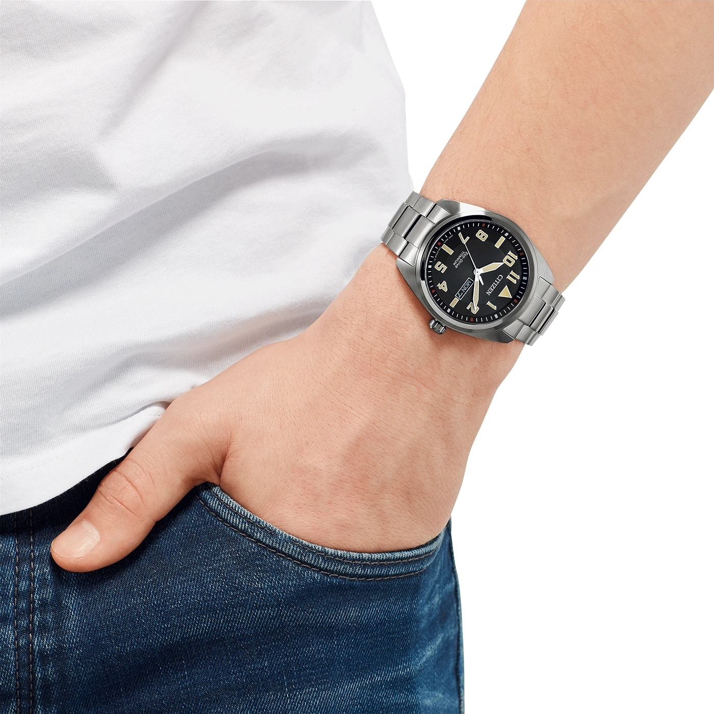 Man wearing a Citizen watch, hand in pocket, white shirt, blue jeans.
