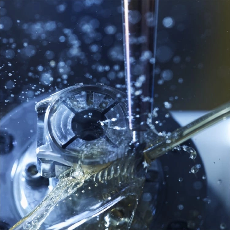 Close-up of a machine tool with water splashing on it, industrial process.
