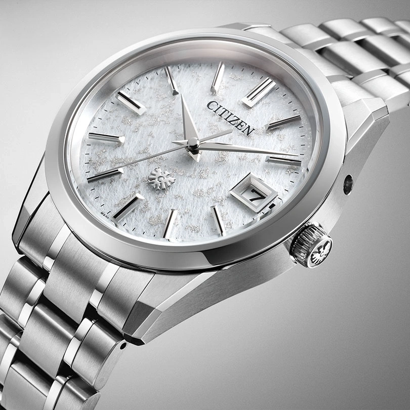 Citizen watch with a white face and silver band, elegant design.