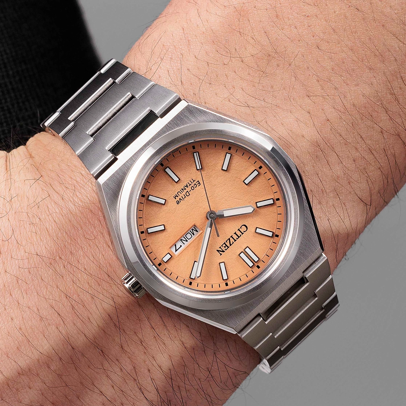 Citizen watch on wrist, titanium, orange dial, day and date display