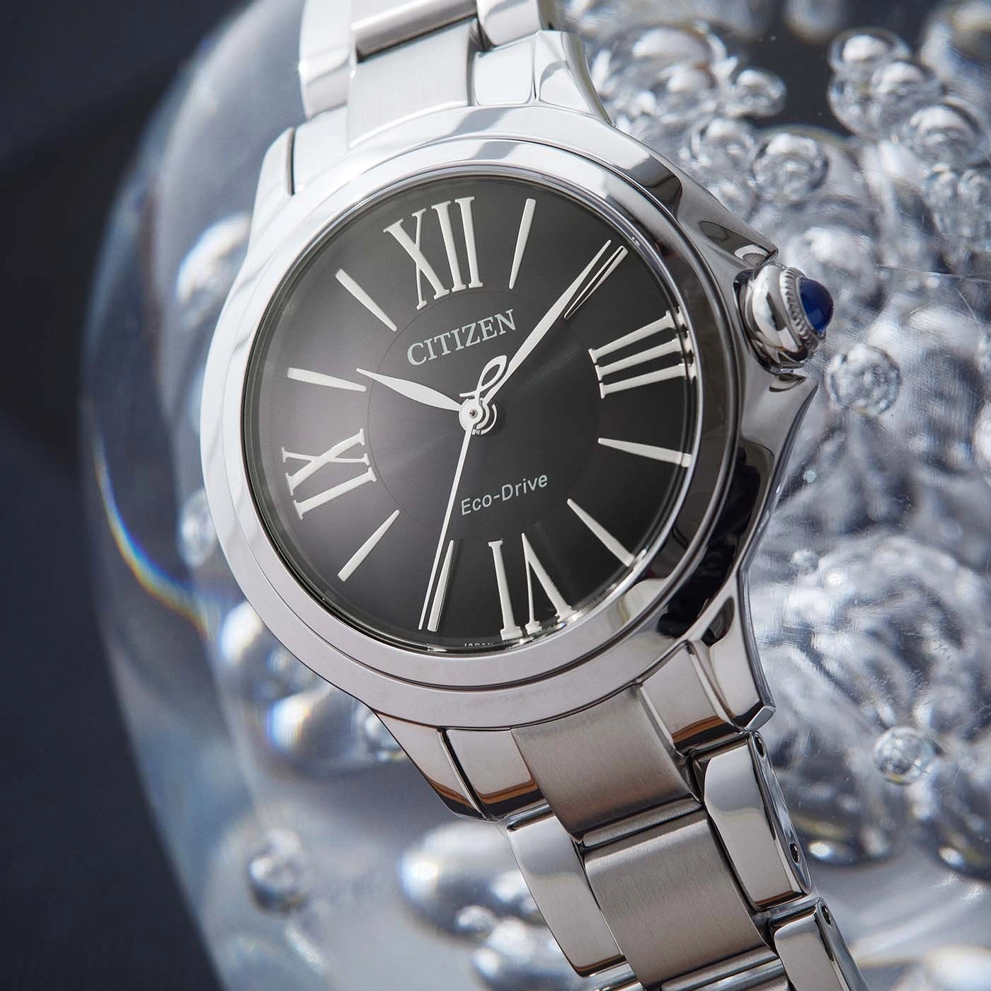 Citizen watch with black face and silver band, close-up shot.