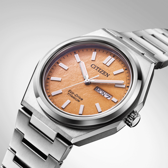 Citizen watch with orange face and titanium band, Eco-Drive technology.