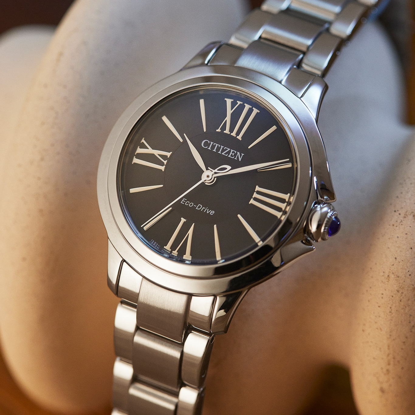 Citizen Eco-Drive watch with black face and silver band, close-up shot.