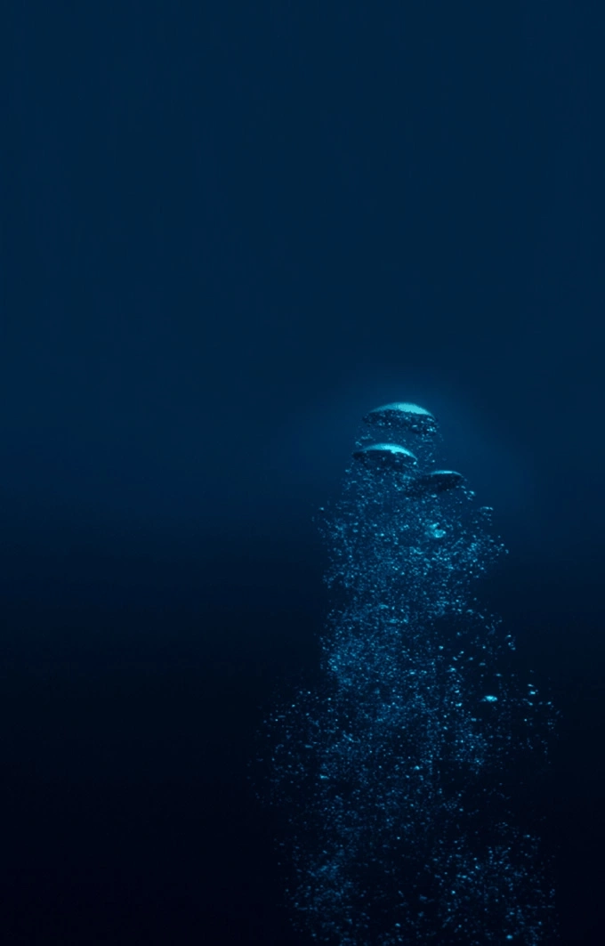Bubbles rising in deep blue water, underwater scene, ocean life