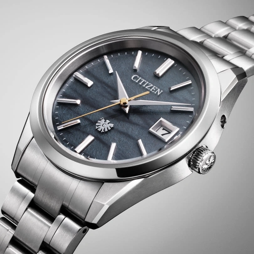 Citizen watch with a dark blue face and silver band, elegant design.