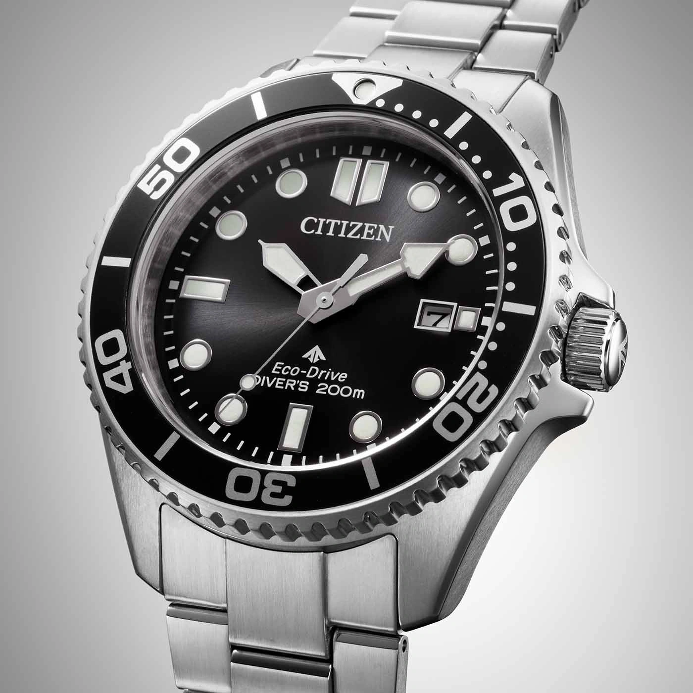 Citizen watch with black dial and silver bracelet, close-up shot.