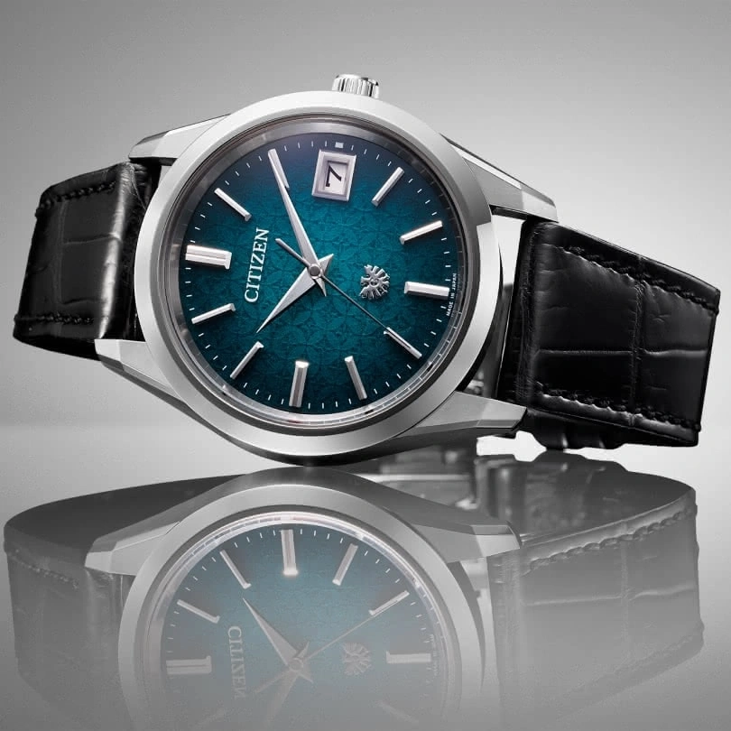 Citizen watch with a blue face and black leather strap, elegant design.