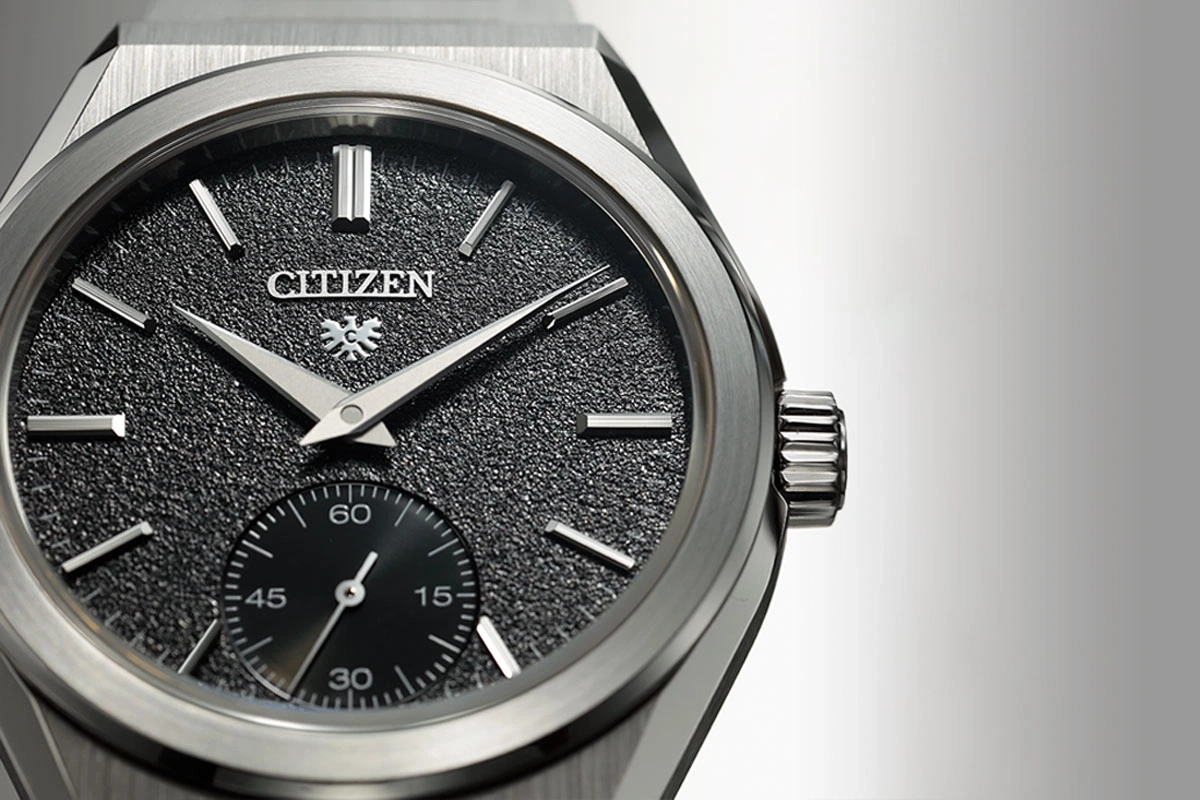Close-up of a Citizen watch with a textured black dial and silver hands.