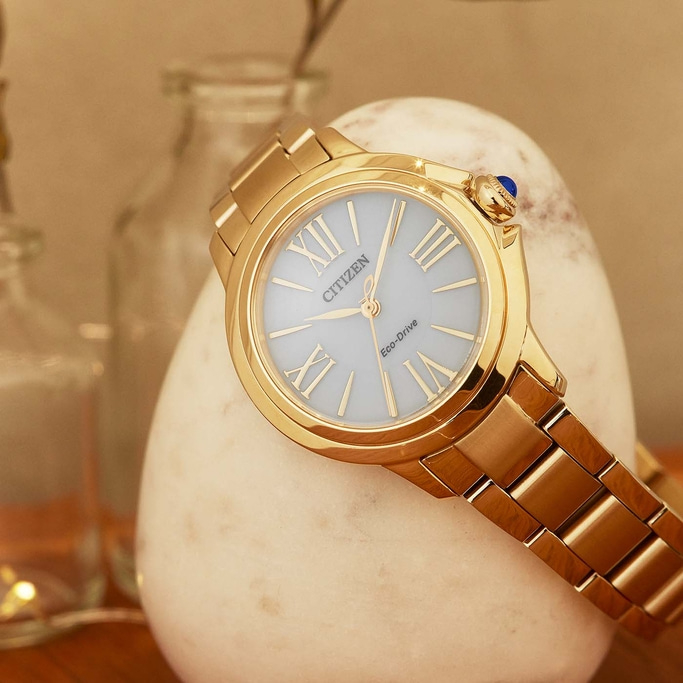 Gold Citizen watch on a white stone, elegant and stylish design.