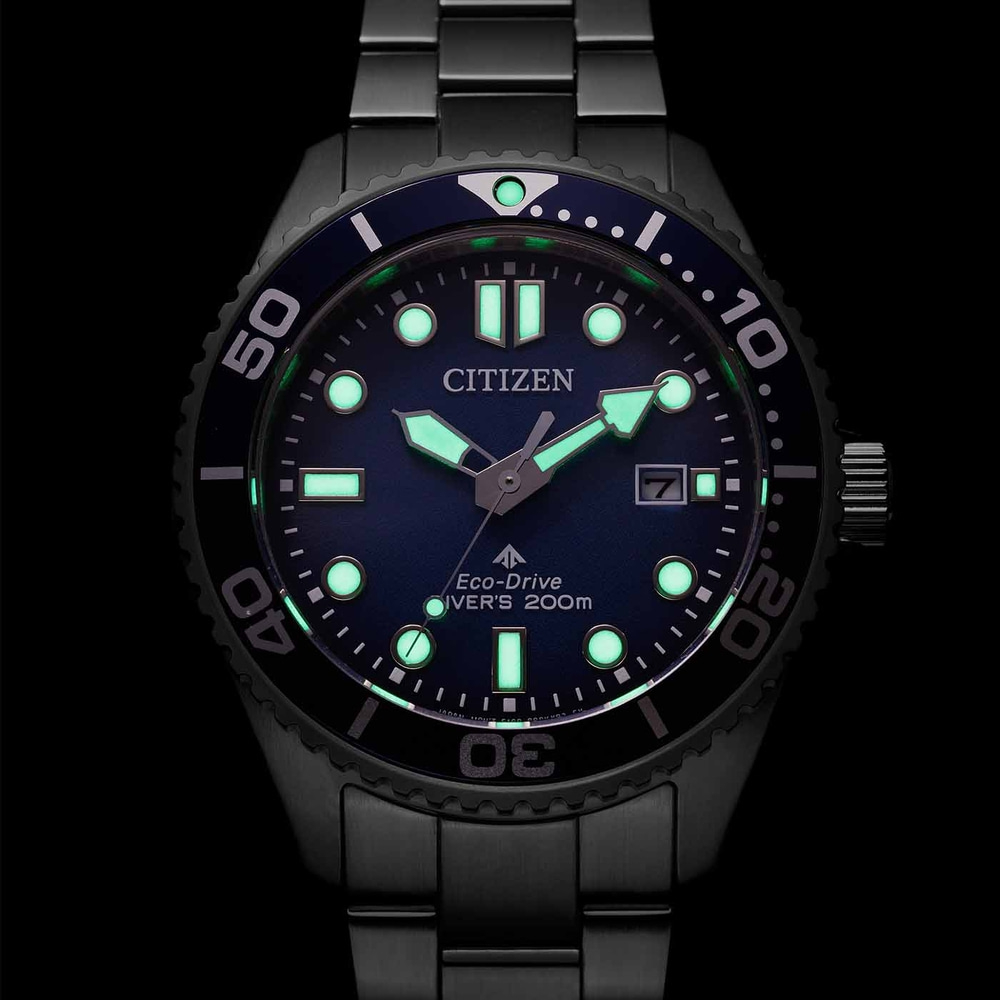 Citizen watch with luminous hands and markers, black bezel, blue dial, and date display.