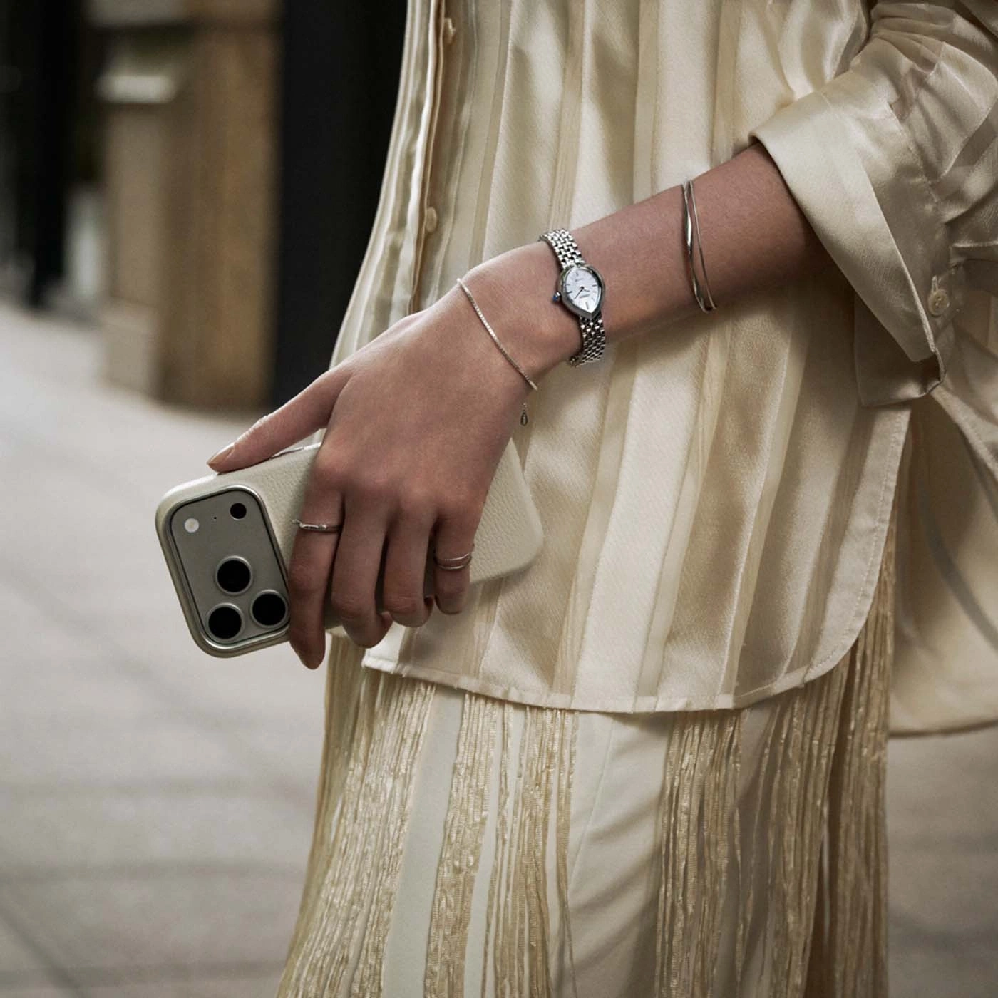 Close-up of a woman's arm with a watch and phone.