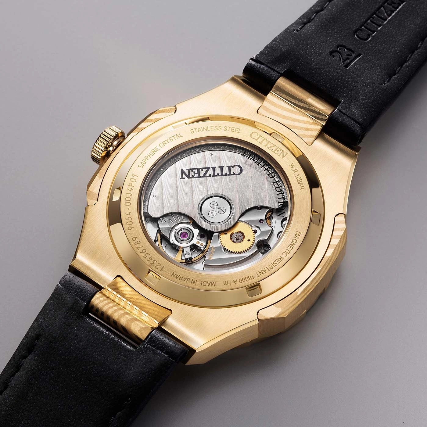 Close-up of a gold Citizen watch back showing the automatic movement and inscriptions.