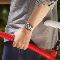 Person in grey shirt holding red bicycle frame, wearing a watch.