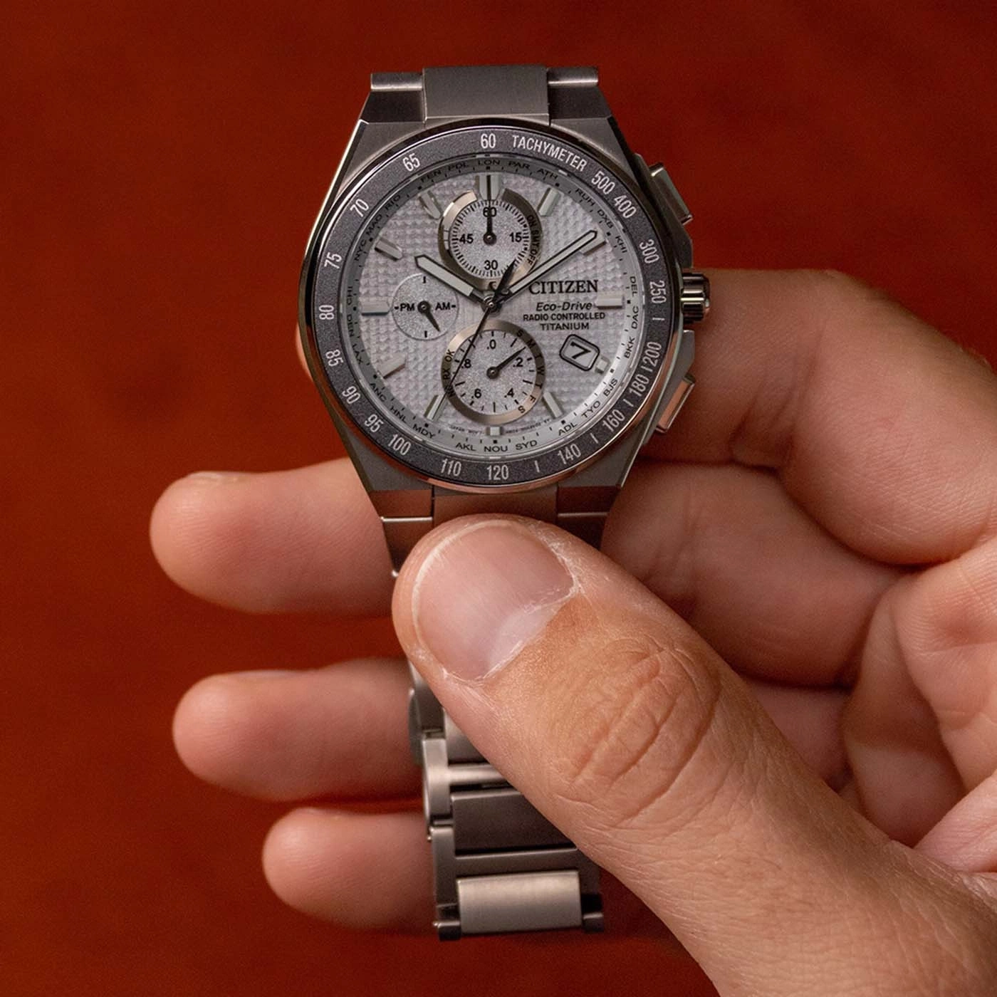 A man holds a Citizen Eco-Drive watch with a silver dial