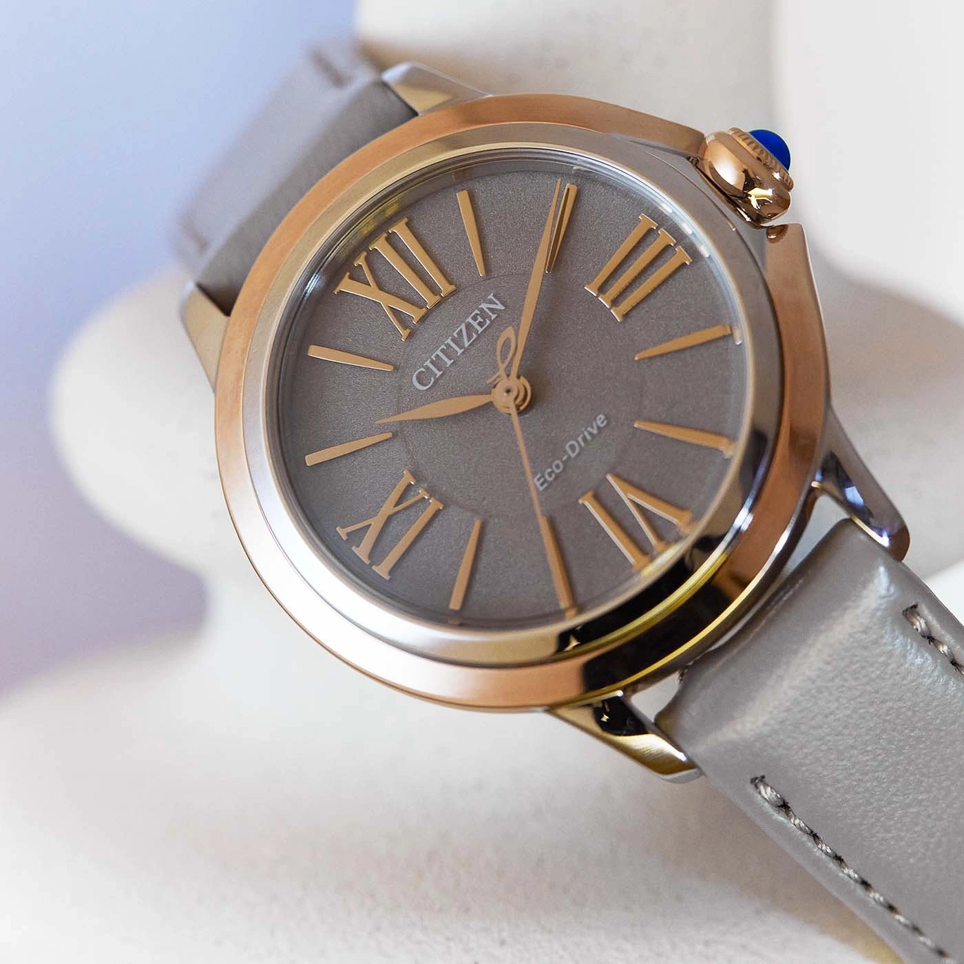Citizen Eco-Drive watch with gray face and leather strap, gold accents.