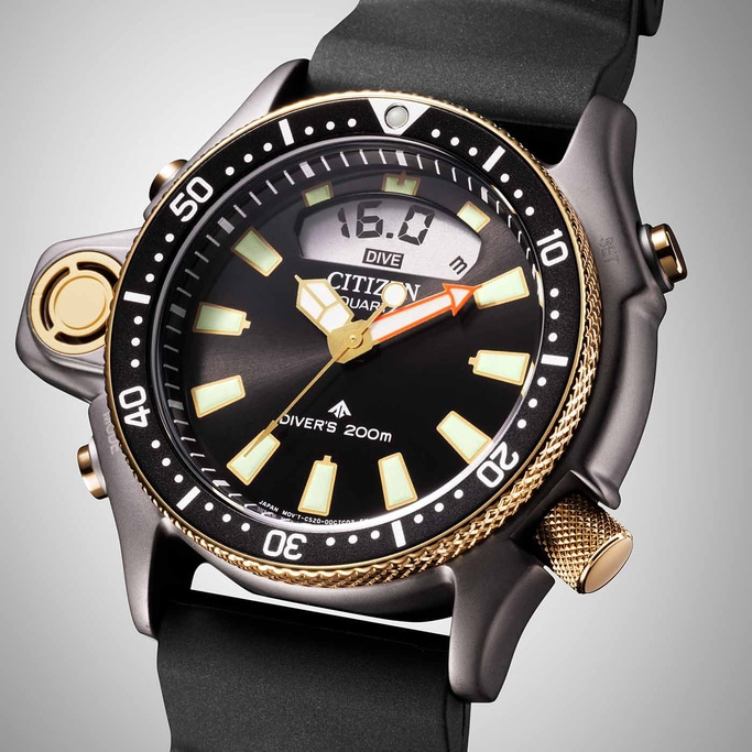 Citizen dive watch with black face, gold accents, and digital display showing depth.