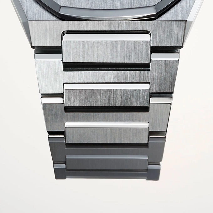 Close-up of a metallic watch strap with brushed metal finish and white accents.