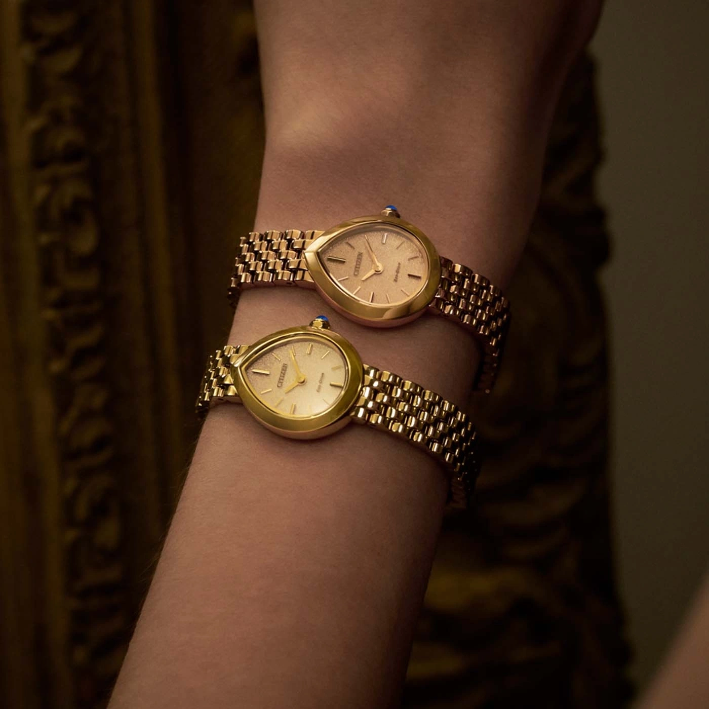 Two gold Citizen watches on a wrist.