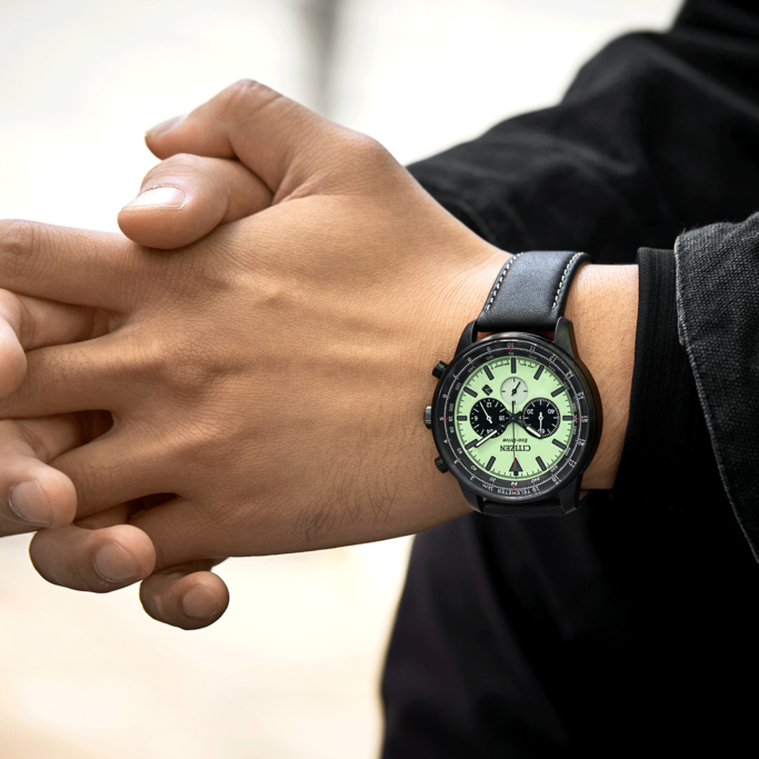 Man wearing a Citizen watch with a black strap and a black jacket.
