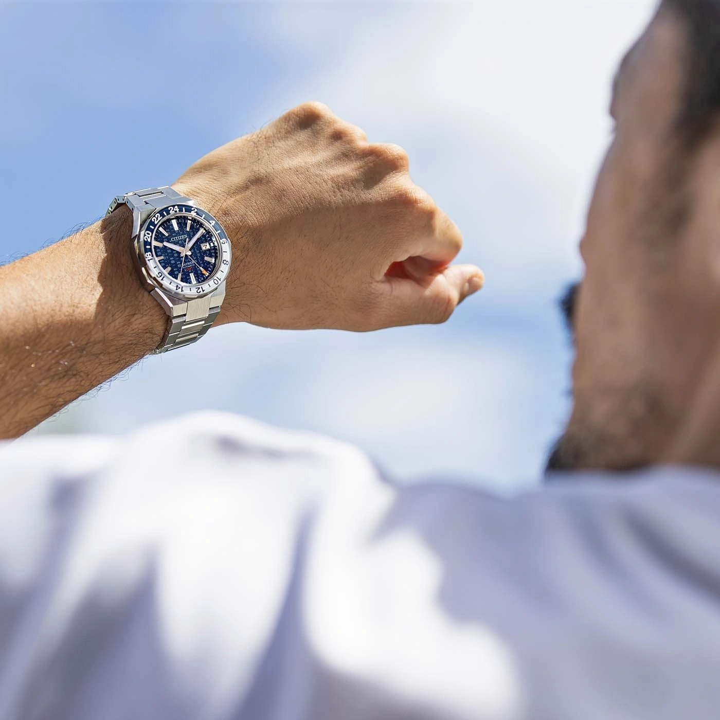Man looking at his watch, blue sky in the background, Citizen watch
