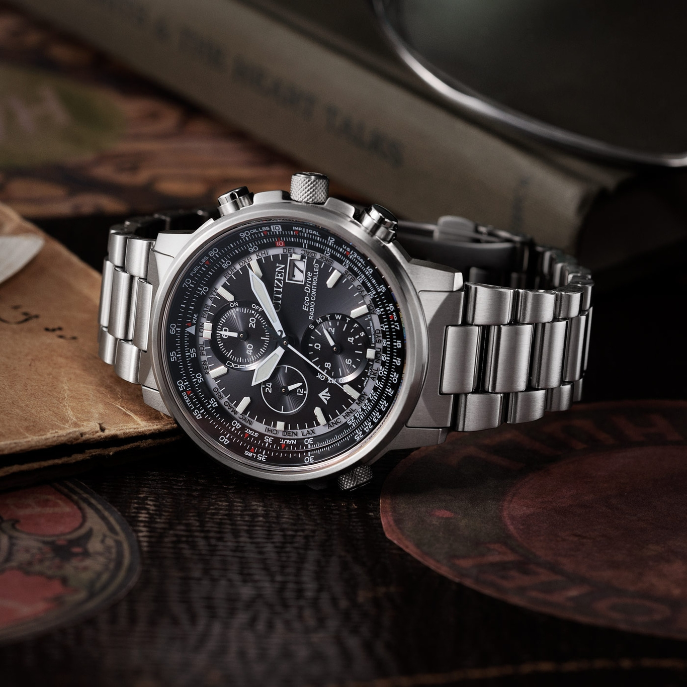 Citizen watch with black face and silver band on a wooden surface.