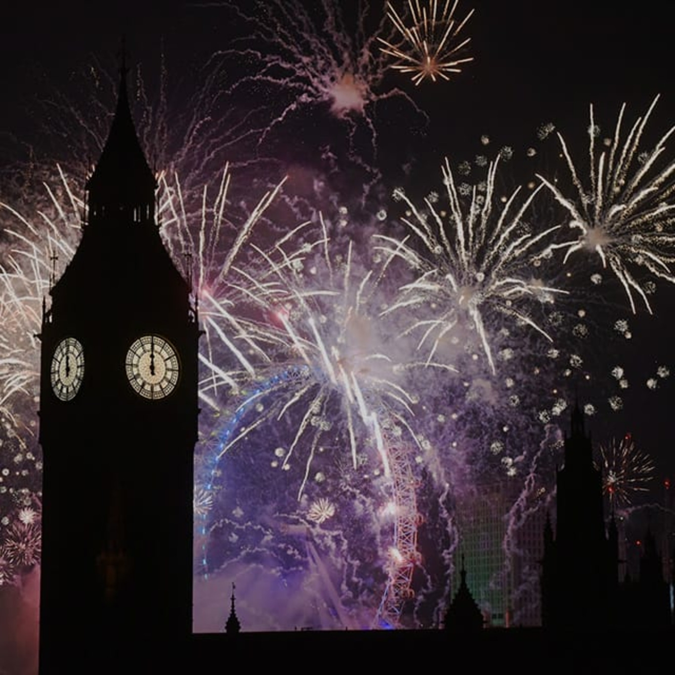 Big Ben silhouetted against fireworks at night, London, UK.