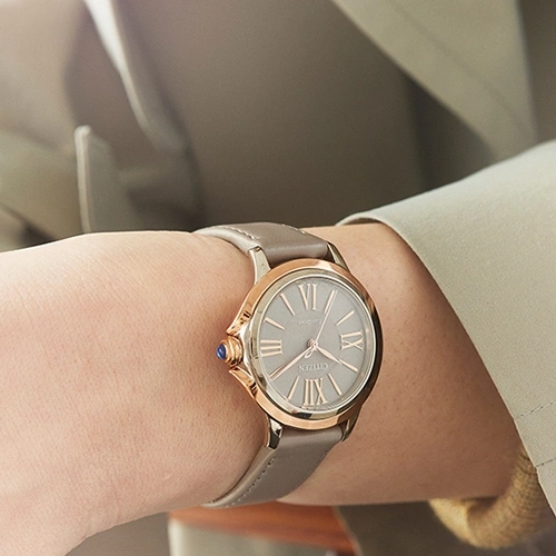 Wrist watch with grey face and leather strap on a person's wrist
