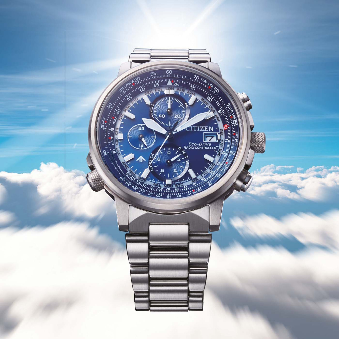 Citizen watch with blue face, stainless steel band, and sky background.