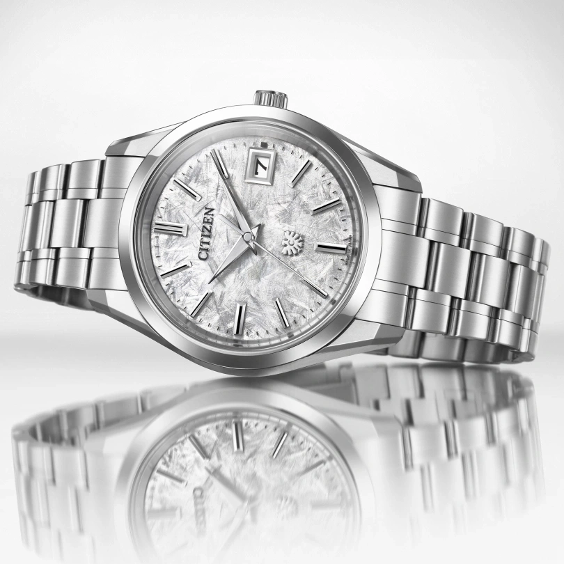 Citizen watch with a silver band and a textured face, elegant design.