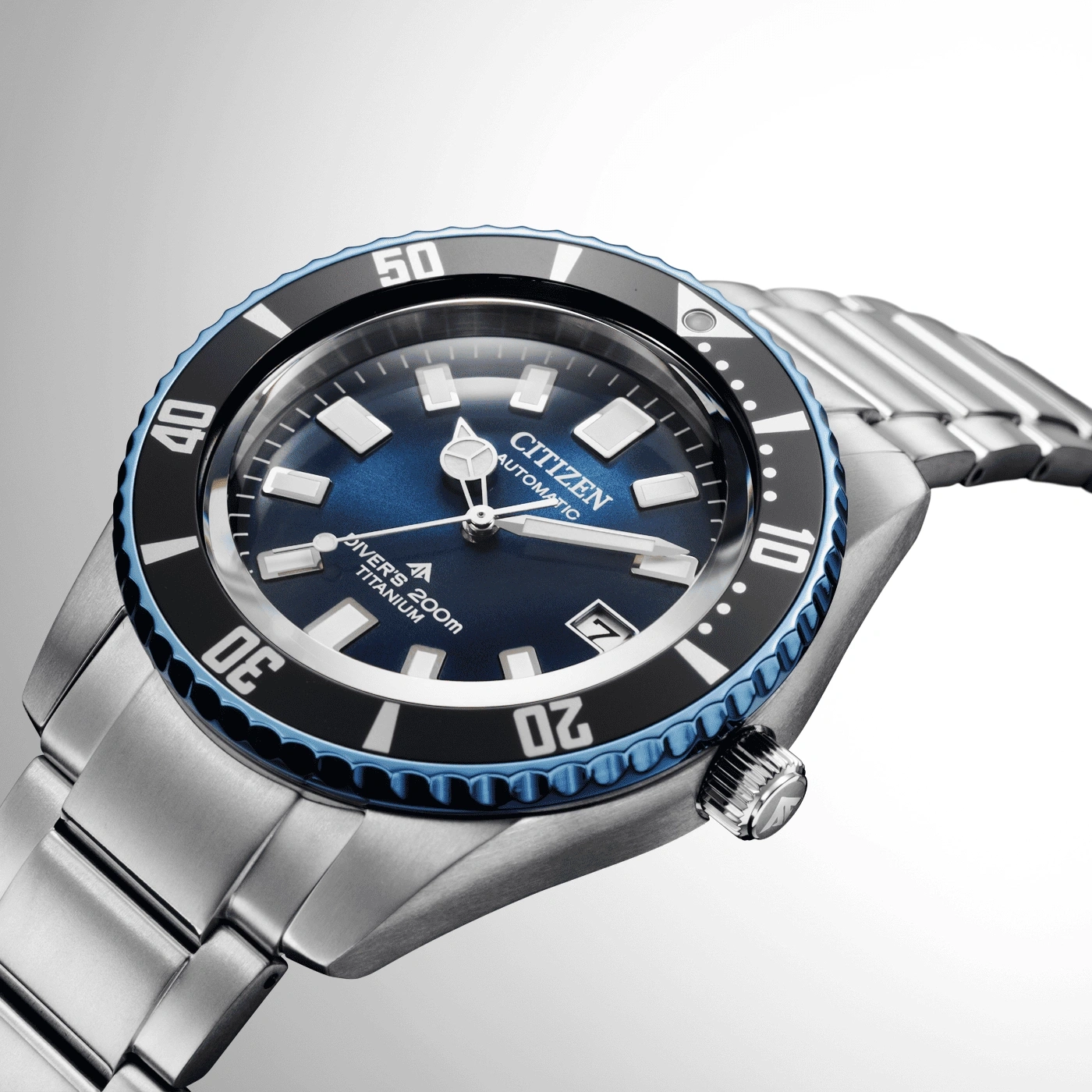 Citizen watch with blue dial and titanium bracelet, close-up shot.