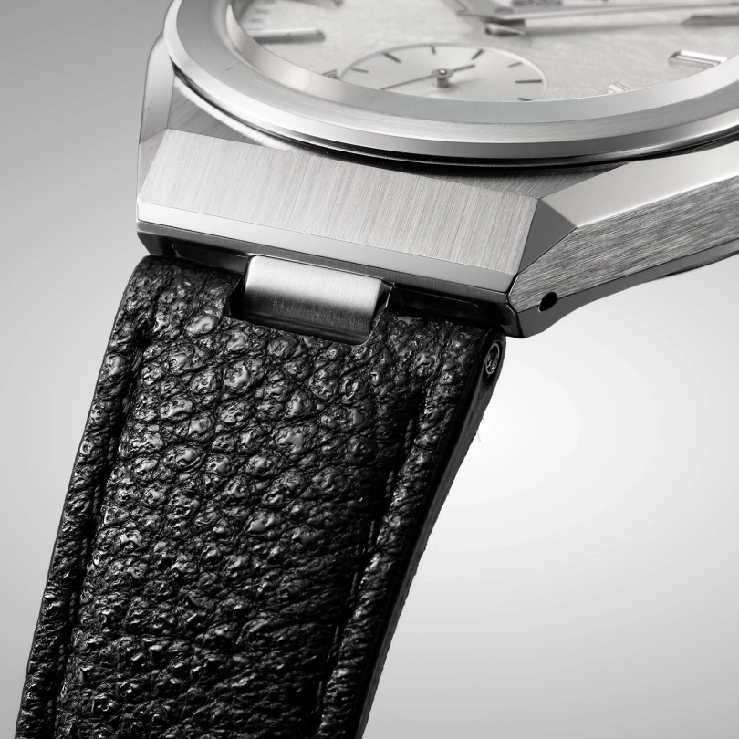 Close-up of a luxury watch with a black leather strap and silver details.