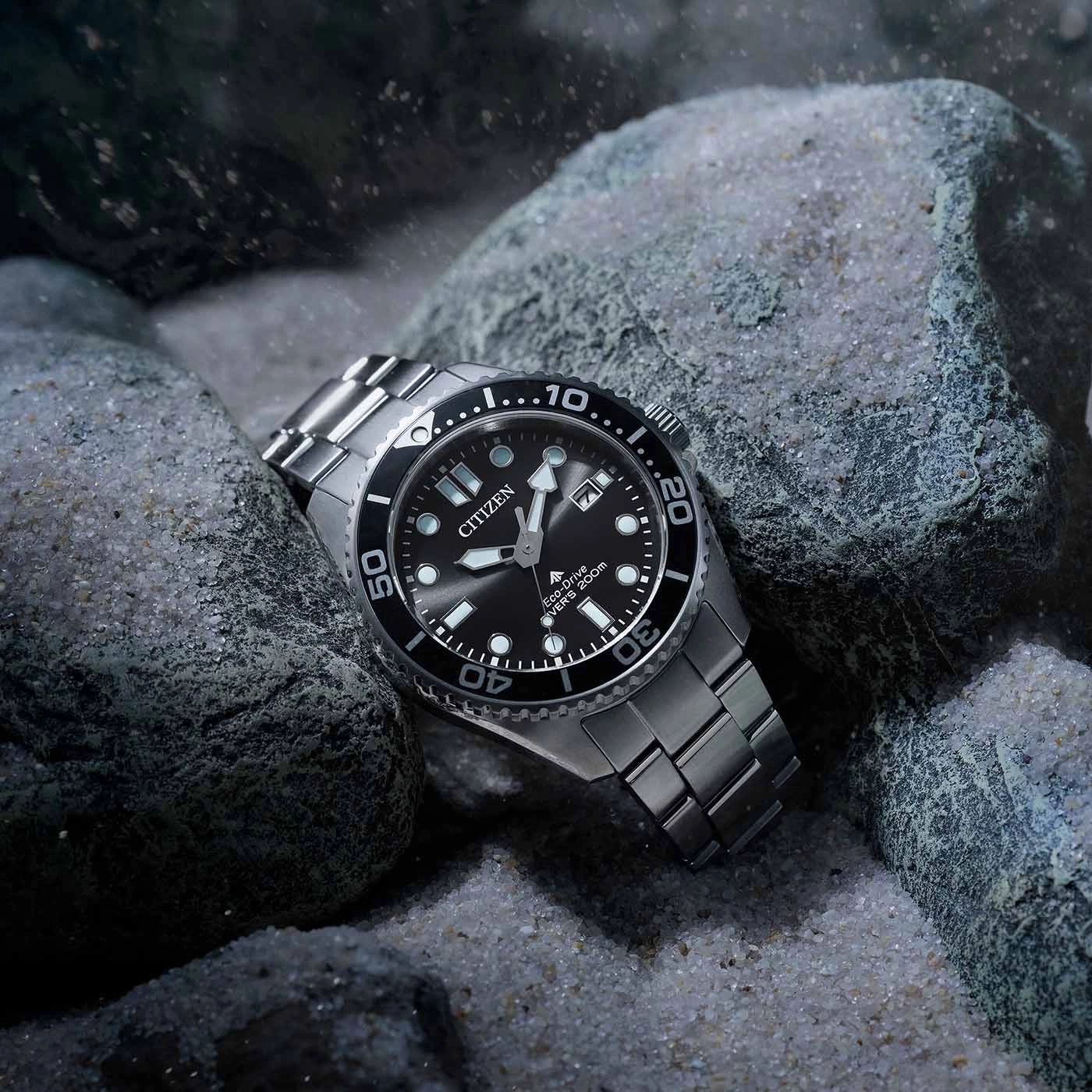 Citizen watch on rocks, black dial, silver bracelet, underwater scene, close-up shot