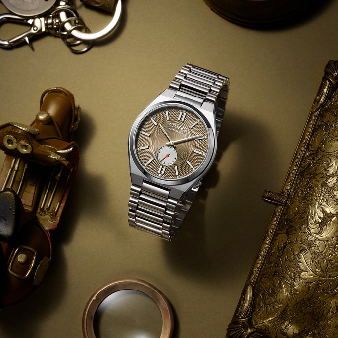 Citizen watch with a gold face, surrounded by vintage accessories.