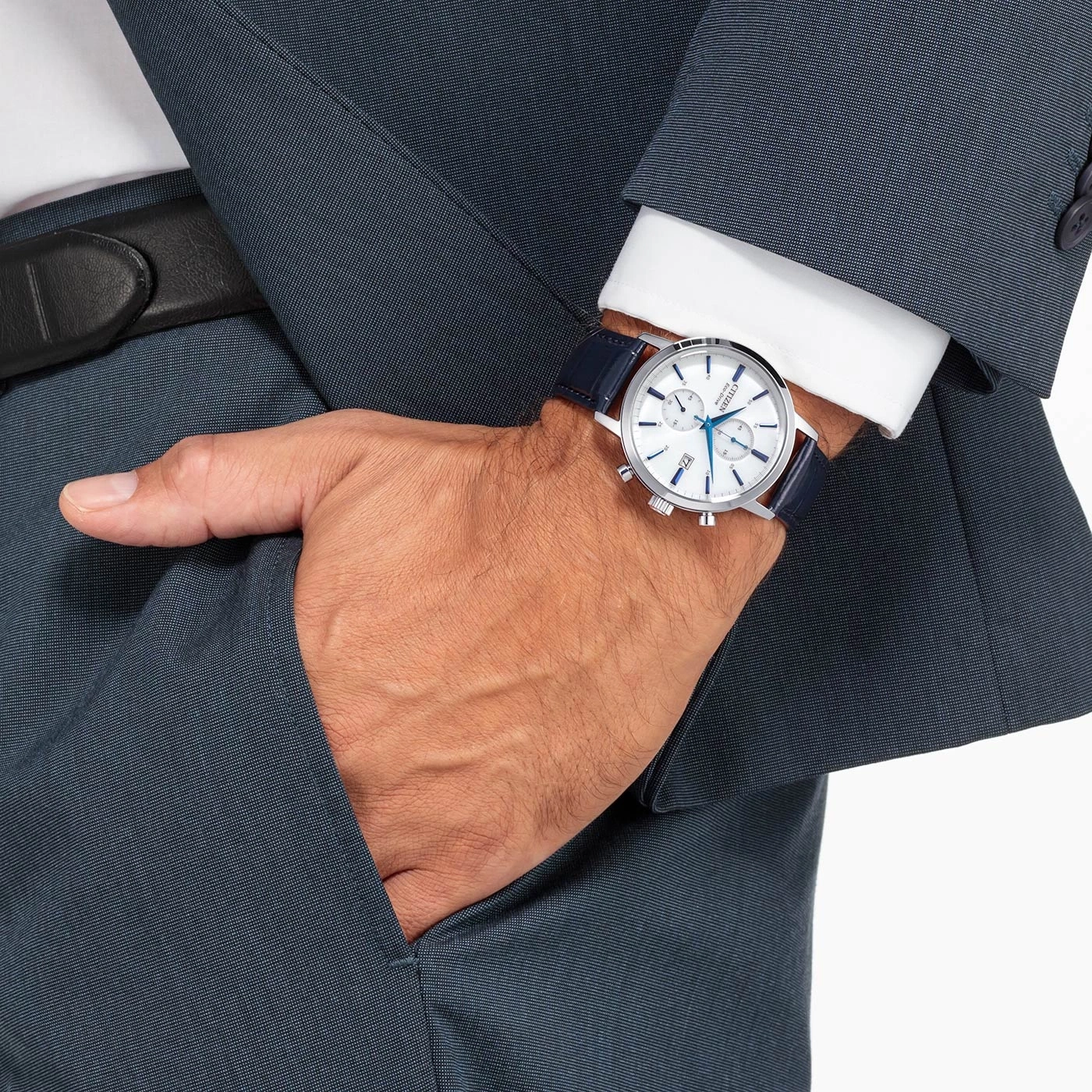Man wearing a watch, suit, and putting his hand in his pocket.