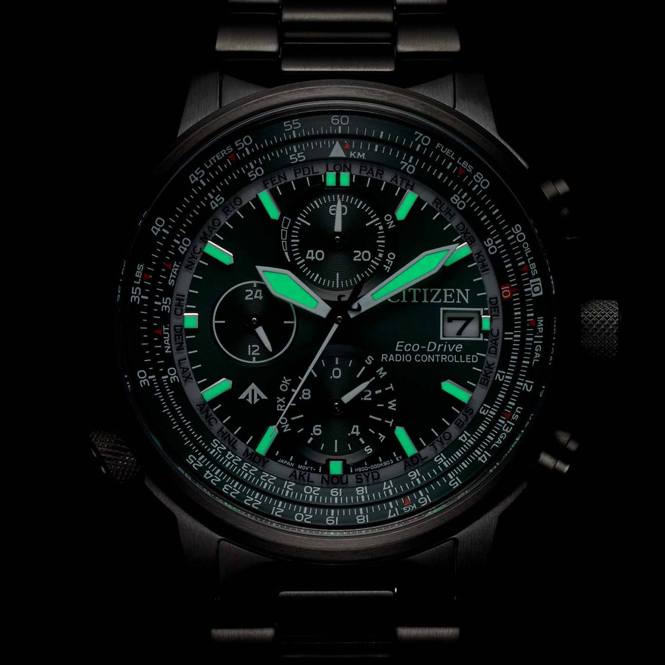 Citizen watch with green accents, luminous hands, and multiple dials, black background.