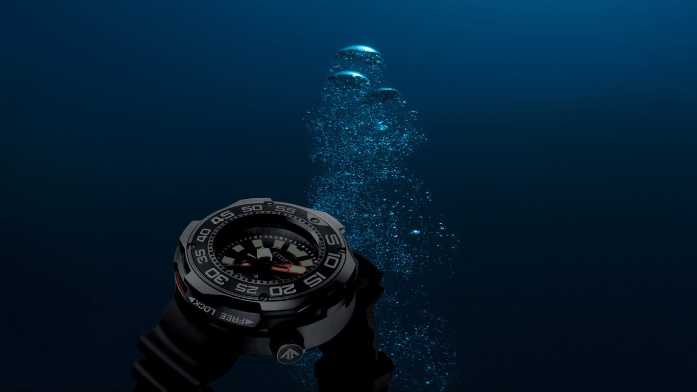 Diving watch underwater with bubbles, showing time and depth, dark blue background.
