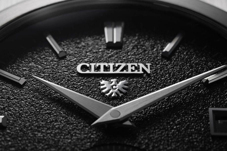Close-up of a Citizen watch face with silver hands and logo.