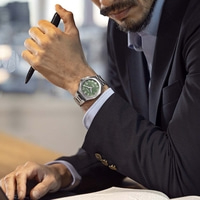 Man in suit with watch and pen at desk