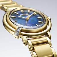 Gold Citizen Eco-Drive watch with blue face and diamond accents, close-up.