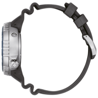 Side view of a silver watch with a black rubber strap on a green background.