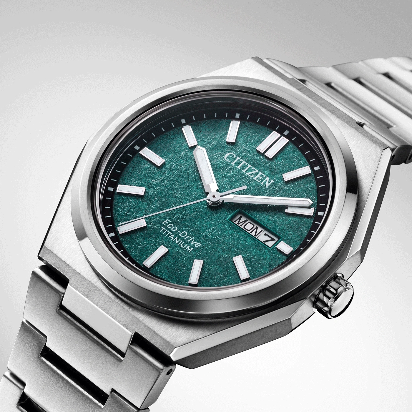 Citizen watch with green face and titanium band, close-up shot.
