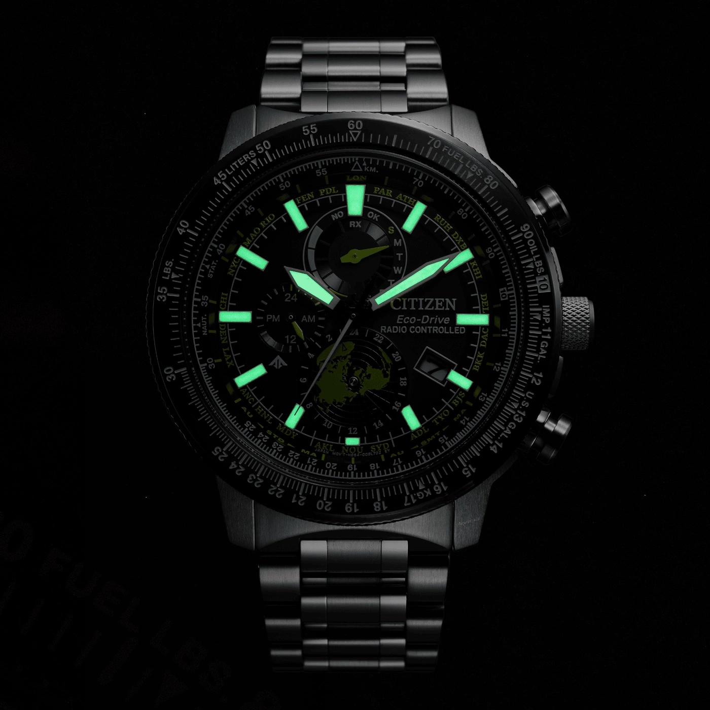 Citizen Eco-Drive watch with glowing hands and markers, black background, time display.
