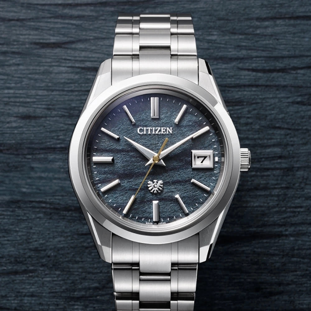 Citizen watch with a blue face and silver band on a dark background